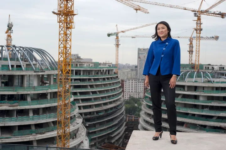 Zhang Xin in Beijing in 2011, standing at the construction site of Galaxy SOHO, an urban complex designed by the late architect Zaha Hadid.
