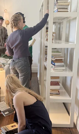 Houseguests help reorganize Holly Peterson’s home library.