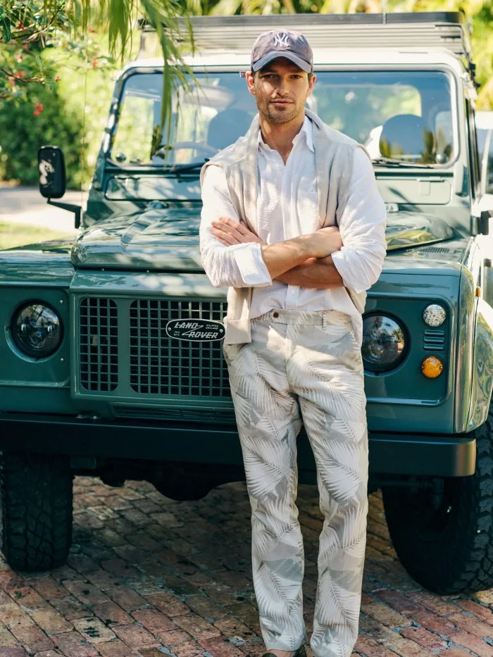 Man wearing Madison Fancy Pants in Vibrant Palms posing in front of a Land Rover.